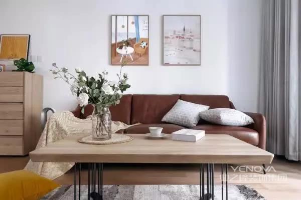 棕色的皮沙发自带大气的感觉，在整体简洁的设计当中，更是给客厅带来一些格调感，背景墙上点缀着两幅装饰画，避免太过单调。