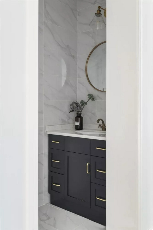 卫生间选用大理石瓷砖搭配黑色浴室柜，深色系便于清洁，抽屉式收纳柜利于分类使用，使空间更加干净整洁。